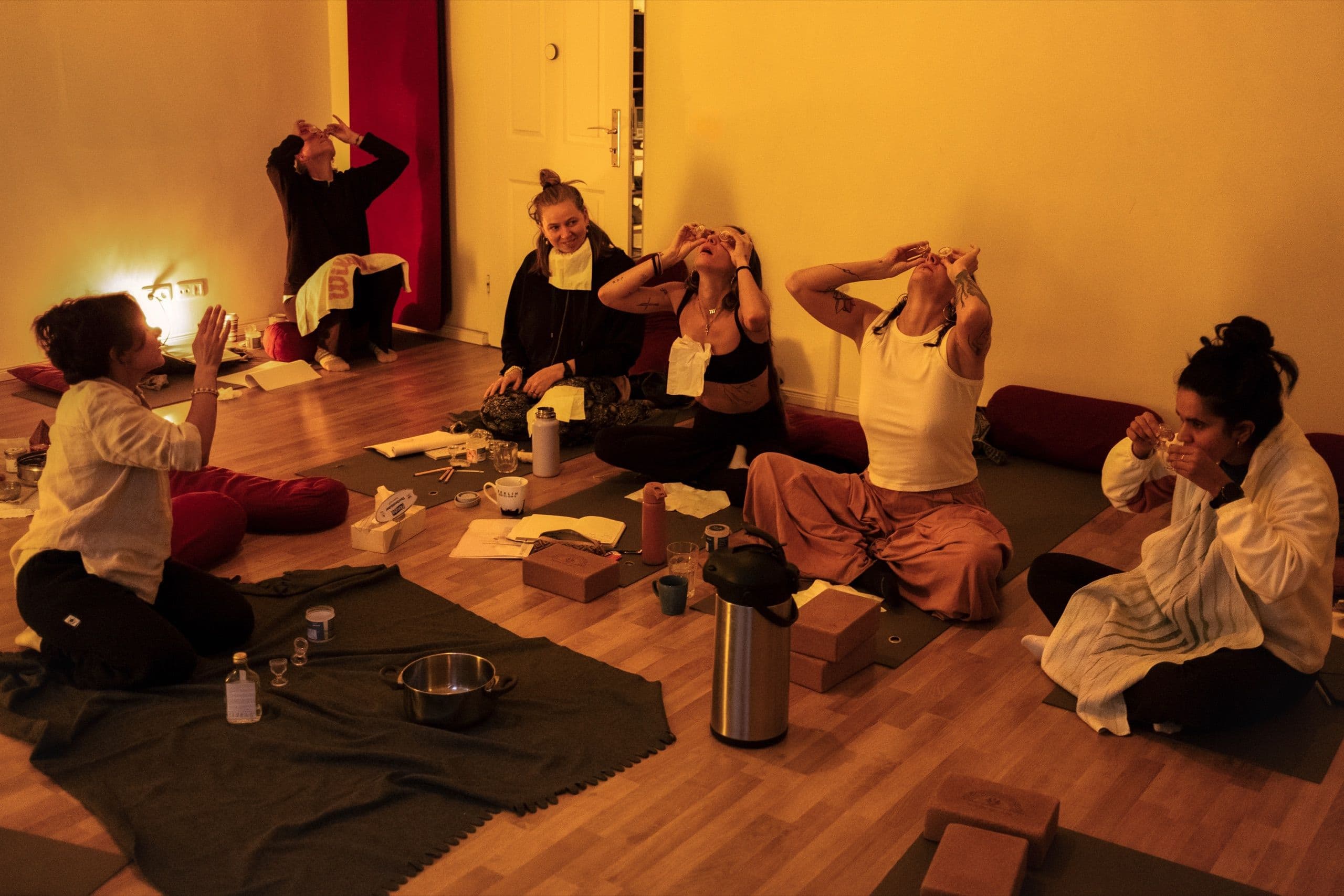 Participants holding small glasses to their eyes during an eye practice in an Ayurveda workshop