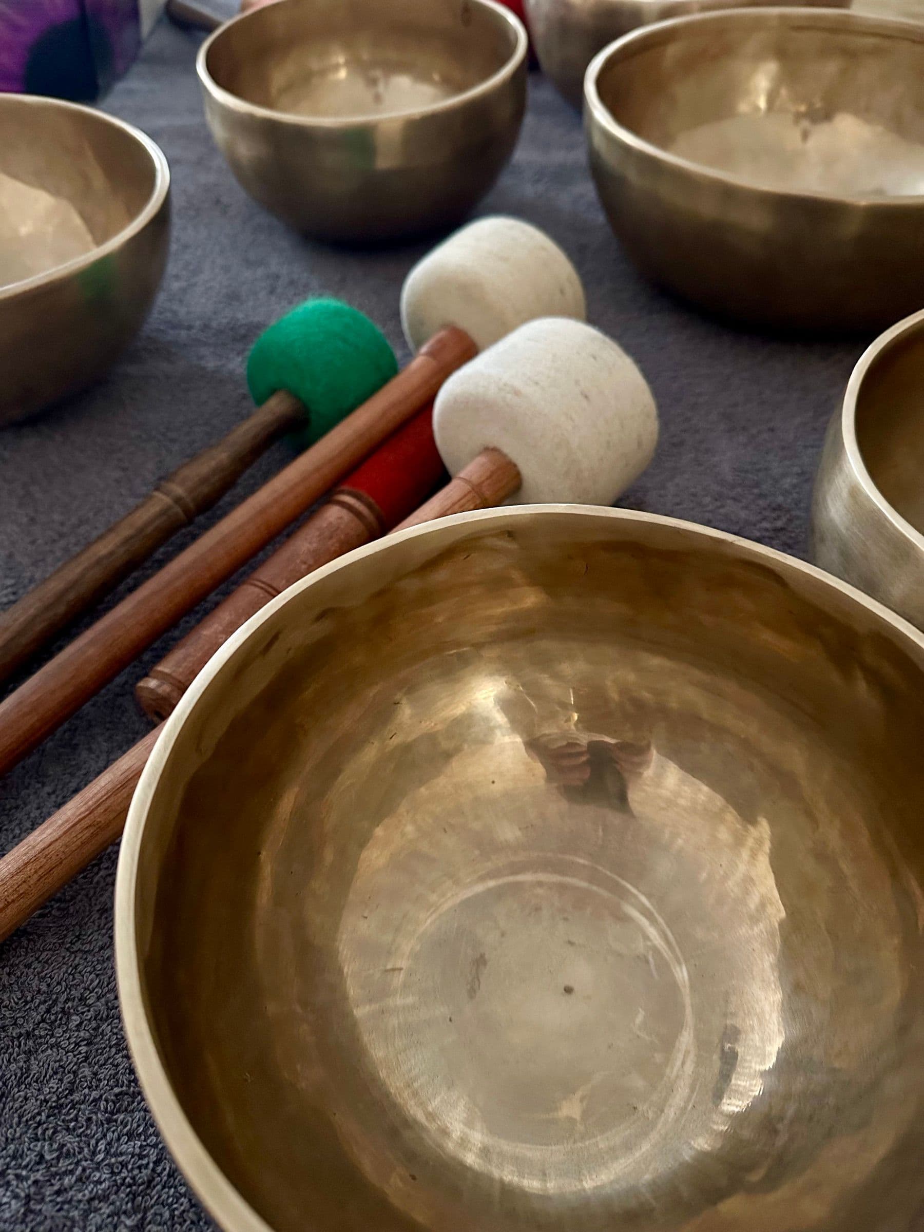 Close-up of Himalayan singing bowls and mallets laid out for a practice session
